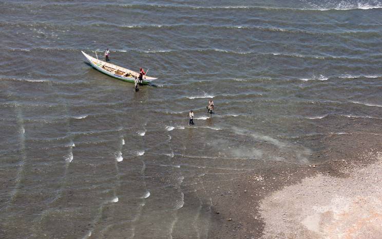 A small boat carrying passengers across East African waters